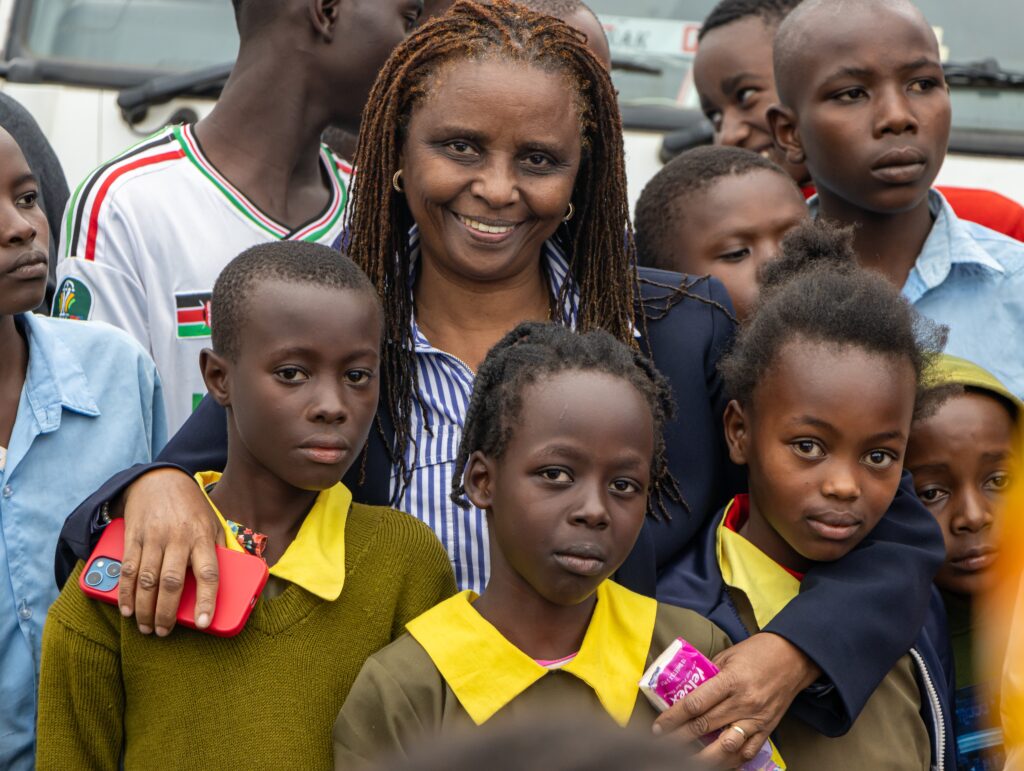 Sarah Muhoya interacts with children at Thirikwa Primary School during the mobile laboratory handover by her family